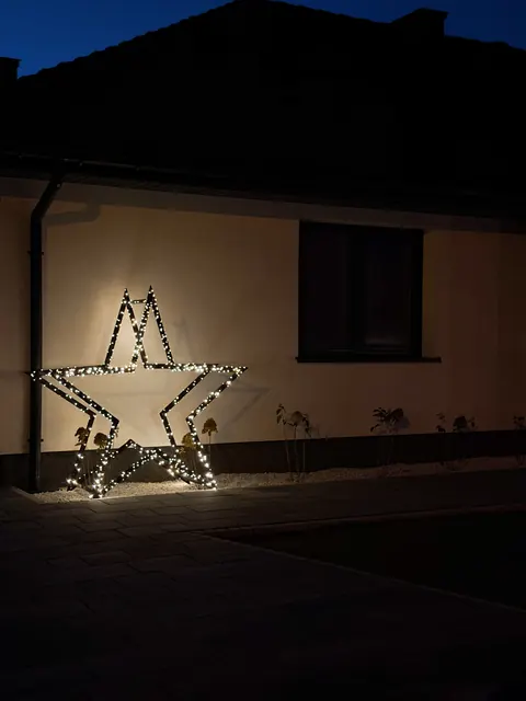 Gwiazda ModoStar na ścianie domu nocą